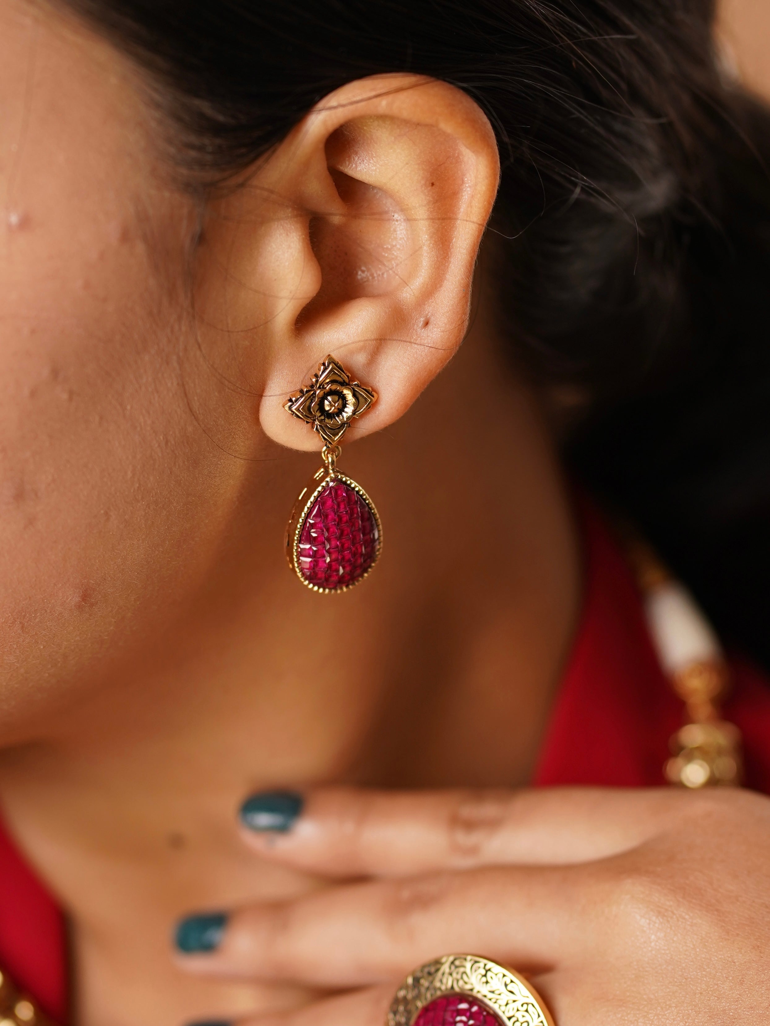 Side view of ruby bloom necklace showcasing carved floral motifs and red accents